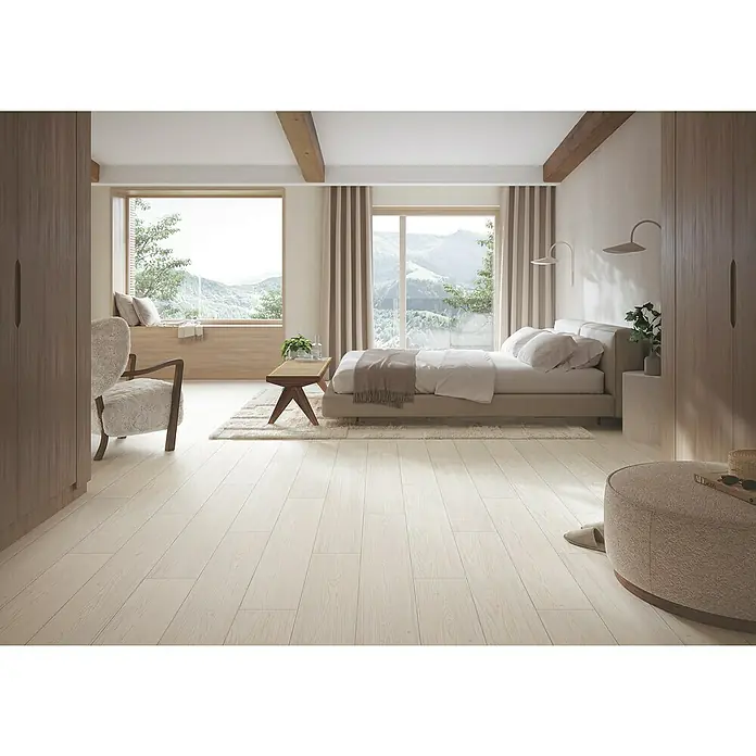 Parador Designbodenmuster Modular ONE Lärche Apollo weiß - 200 x 194 x 8 mm, Landhausdiele - Schlafzimmer mit hellem Holzboden, Bett, Sessel und Fenster mit Bergblick. Gemütliche Atmosphäre mit natürlichem Licht.
