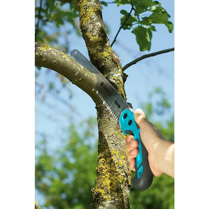Gardena Sierra de podar manual 300 P - Largo: 495 mm, Plástico, Plateado, Negro, Turquesa - Primer plano de una sierra de podar Gardena cortando una rama, ideal para jardinería y mantenimiento de árboles.