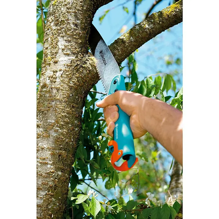 Gardena Combisystem Hand-Astsäge 300PP - Länge: 514 mm, Kunststoff, Silber, Türkis - Eine Handsäge der Marke Gardena schneidet einen Ast ab, ideal für Gartenarbeiten und Baumschnitt.