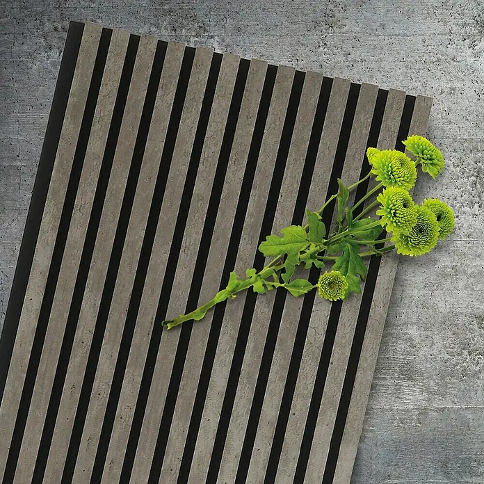 FibroTech Akustikpaneel Stone - Cement Stone, L x B x S: 2.440 x 520 x 18 mm - Nahaufnahme einer geriffelten Wandpaneele mit grünen Blumen. Die Rillen sind in Grau und Schwarz gehalten und verleihen dem Paneel ein modernes Aussehen.