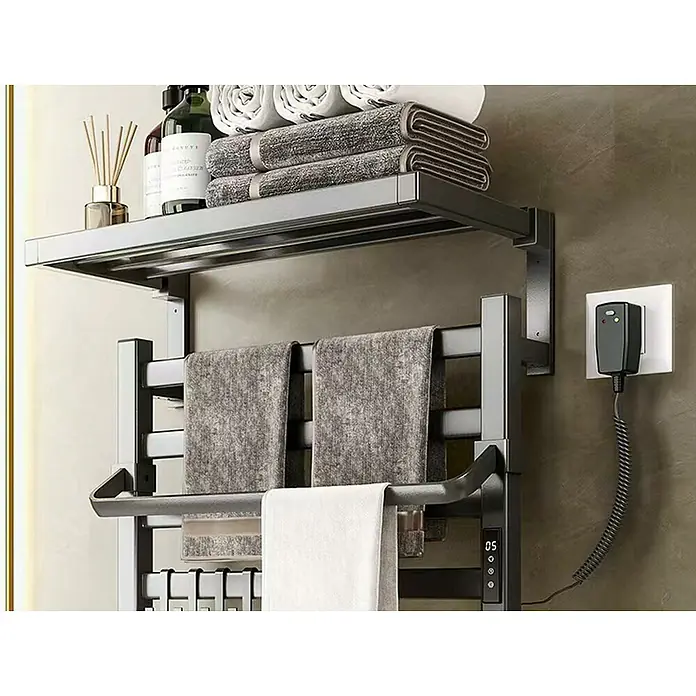 Purline Radiador toallero eléctrico NTW-09 - An x Al: 57 x 39 cm, 55 W, Negro - Primer plano de un moderno toallero eléctrico con estante y toallas y productos para el cuidado apilados.