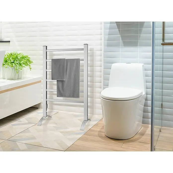 Purline Elektro-Badheizkörper NTW-05 - B x H: 53 x 90 cm, 100 W, Silber - Ein stilvoller, freistehender Handtuchwärmer aus Chrom mit zwei grauen Handtüchern hängt im Badezimmer.