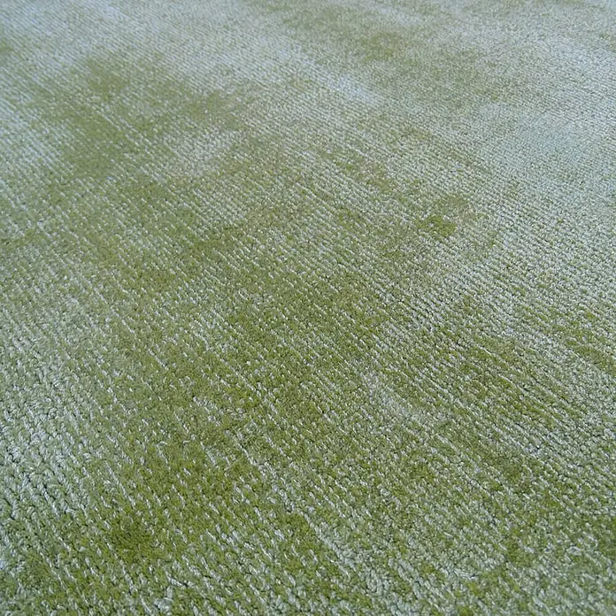 Kayoom Kurzflorteppich LuxuryEdelgrün, 170 x 120 cm, 100 % Viskose - Nahaufnahme eines grünen Teppichs mit einer feinen Textur, ideal für Wohnräume.