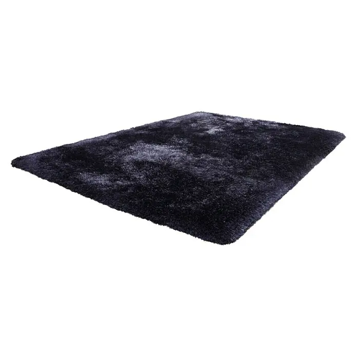 Kayoom Hochflorteppich Cosy - Blau, 290 x 200 cm, 100 % Polyester - Ein rechteckiger, dunkelblauer Hochflorteppich mit langen Fasern liegt auf einer weißen Oberfläche und sorgt für Komfort und Wärme.