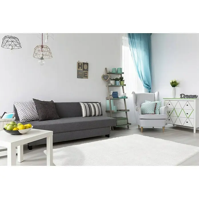 Kayoom Hochflorteppich Bali - Elfenbein, 150 x 80 cm, 100 % Polyester - Wohnzimmer mit grauem Sofa, weißem Teppich und Dekorationsgegenständen. Die Hängelampen verleihen dem Raum eine moderne Note.