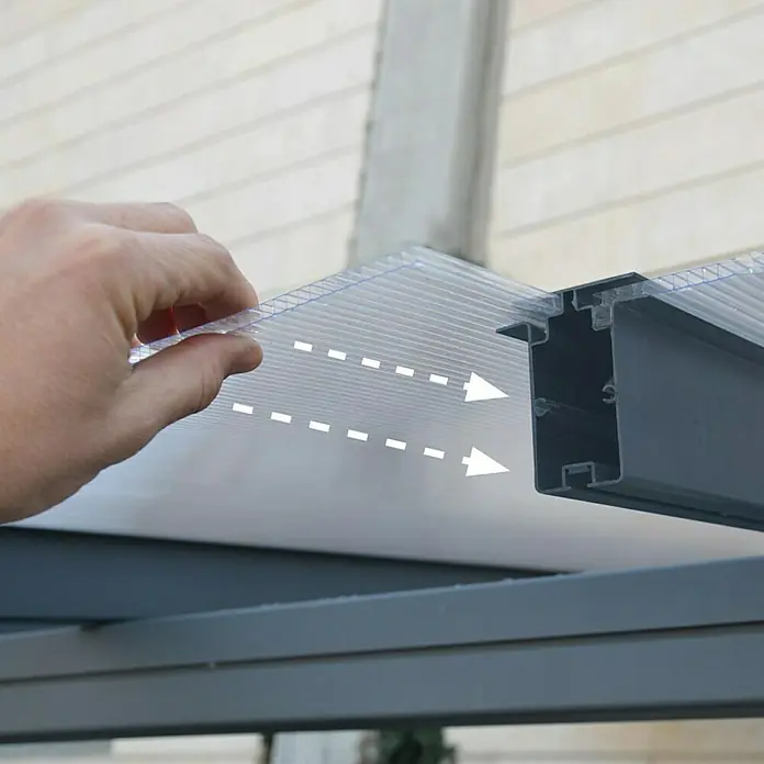 Palram – Canopia Carport Verona 5000 - Medidas ext. (An x Pr): 5,04 x 2,99 m, Aluminio, Carport adecuado para: Turismos - Primer plano de una persona deslizando una lámina de policarbonato en un perfil de aluminio para construir un toldo.