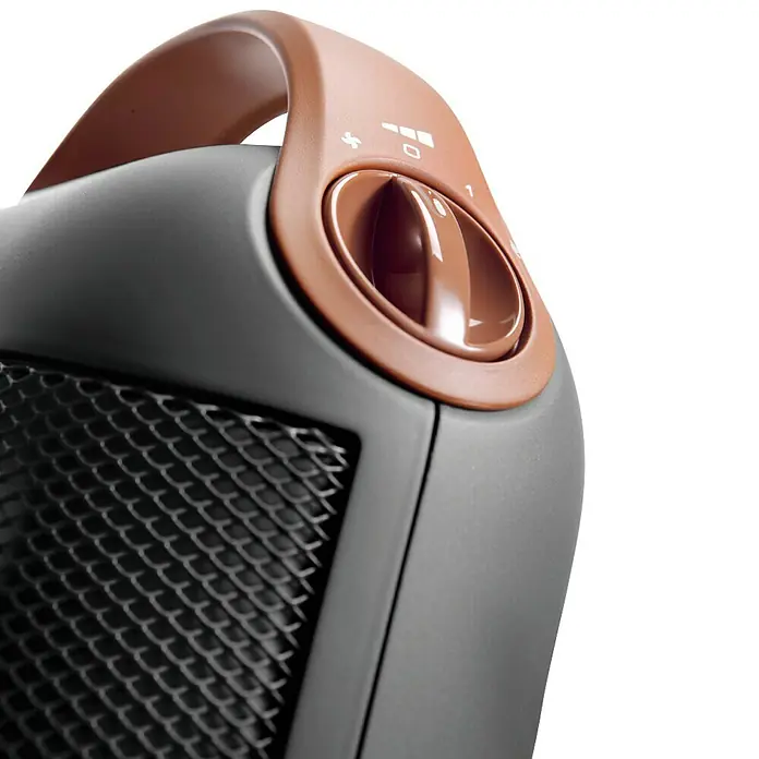 De'Longhi Calefactor de aire Capsule - 900 W - 1.800 W, Gris oscuro - Primer plano de un calentador gris con asa marrón y un dial para ajustar la temperatura.