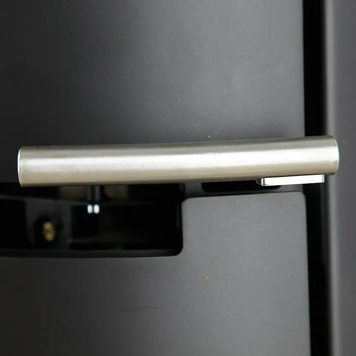 Aduro Kaminofen 9 - 8 kW, Raumheizvermögen: 334 m³, Material Verkleidung: Stahl, Schwarz - Detailaufnahme eines modernen Ofens mit einem eleganten, silberfarbenen Griff, der sich harmonisch in das dunkle Design einfügt.