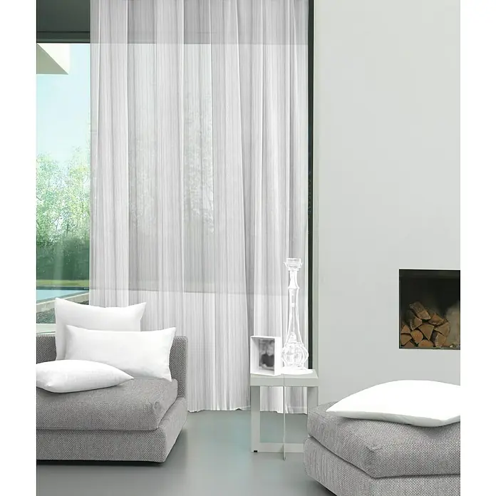 Visillo para ventana Taj - 140 x 250 cm, 100% poliéster, Blanco/gris - Diseño interior con cortinas claras, tapicería gris y candelabro transparente, ideal para un ambiente moderno de sala de estar.