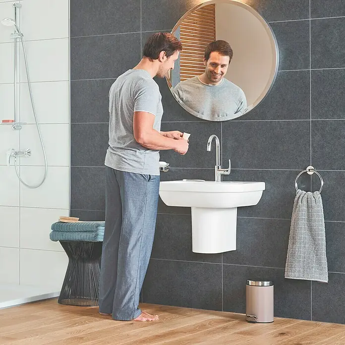 Grohe Essentials Handtuchring - Chrom, Glänzend - Ein moderner Waschtisch mit einer schlanken Armatur und einem runden Spiegel in einem stilvollen Badezimmer. Ideal für zeitgemäße Badezimmerdesigns.