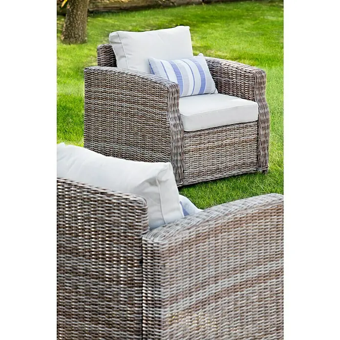 Sillón de exterior Gotland - An x Pr x Al: 80 x 81 x 77 cm, Aluminio/Ratán sintético, Beige - Dos sillones de jardín de ratán con cojines blancos y un cojín decorativo a rayas sobre un césped verde. Ideal para relajarse al aire libre.