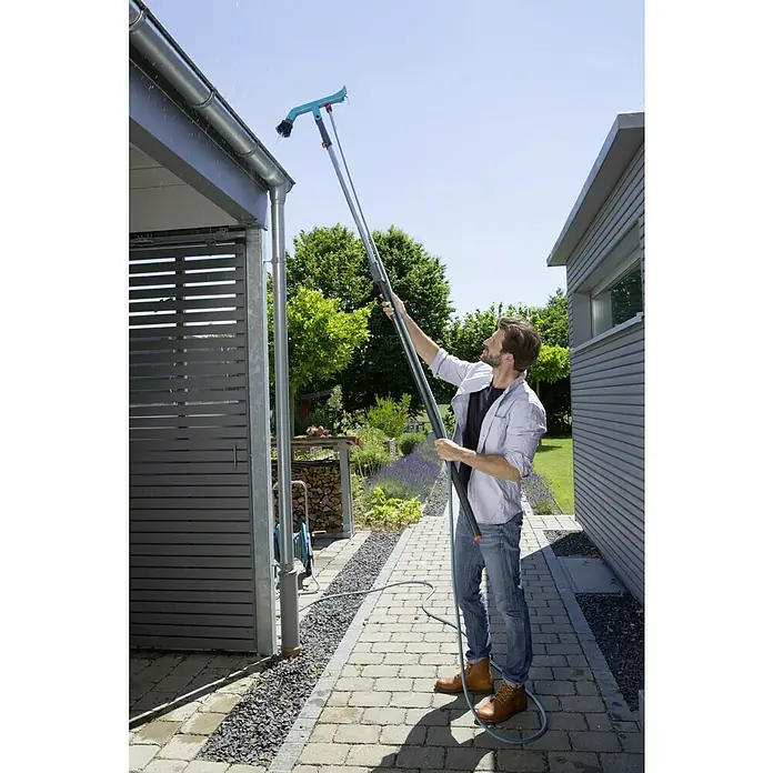 Gardena Combisystem Dachrinnenreiniger - Passend für: Gardena Combisystem Stiele - Mann reinigt Dachrinne mit einer GARDENA Dachrinnenbürste, die an einer Teleskopstange befestigt ist.