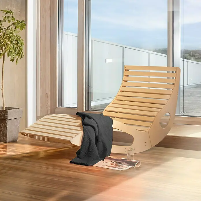 Weka Komfortliege Balance - 165 x 64 x 95 cm - Einladender Innenbereich mit einer hellen Holzliege, einer weichen Decke und einem Magazin, perfekt zum Entspannen und Lesen am Fenster.