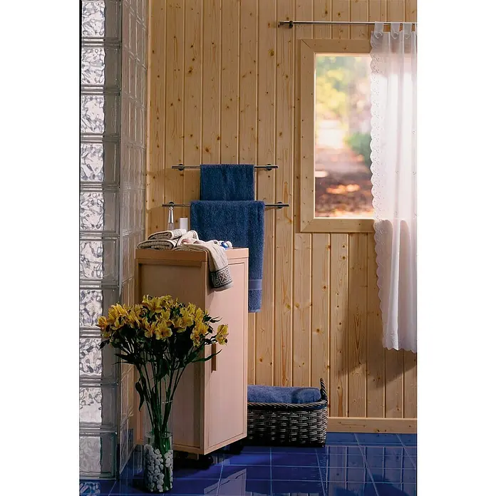 Panel de pared Frisolar Barnizado - 240 cm x 95 mm x 10 mm - Cuarto de baño luminoso con paredes de madera, toallas azules y baldosas azules. El ramo de flores amarillas aporta un toque de color a la habitación.