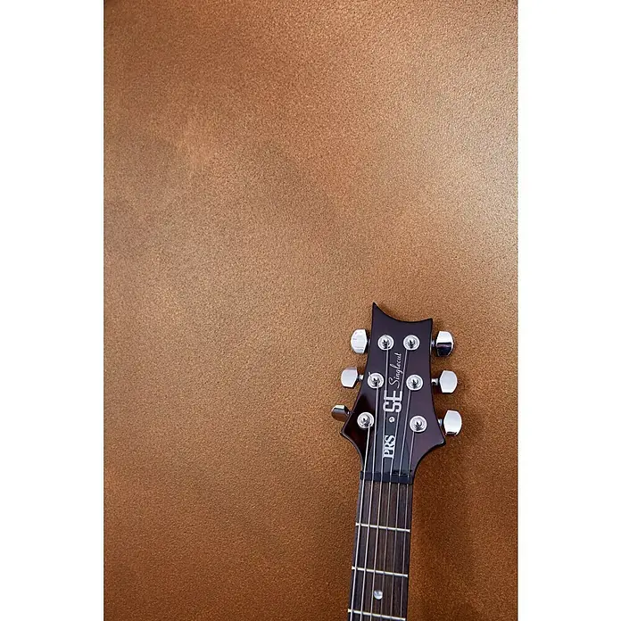 SCHÖNER WOHNEN-Farbe Trendstruktur Dekoputz-Set Rost-Optik - 6 -tlg. - Nahaufnahme einer PRS SE Singlecut E-Gitarre, die Details des Headstocks und der Saiten zeigt, vor einem goldenen Hintergrund.
