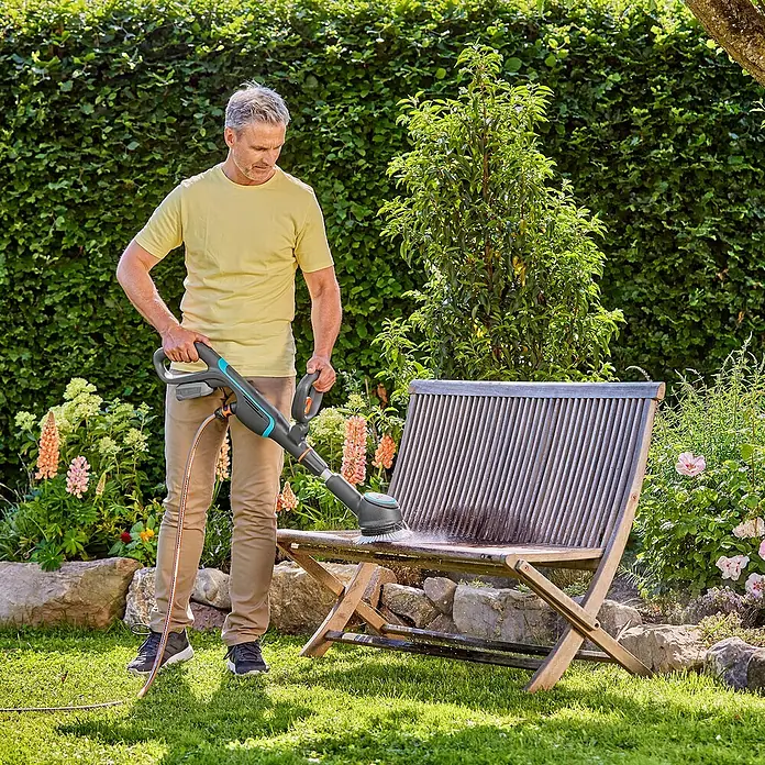 Gardena Power for All 18V Akku-Reinigungsbürste AquaBrush Compact 02/18V - Ohne Akku - Ein Mann reinigt eine Gartenbank mit dem Gardena Akku-Bürstenreiniger EasyClean. Der Reiniger entfernt Schmutz mühelos und effektiv.