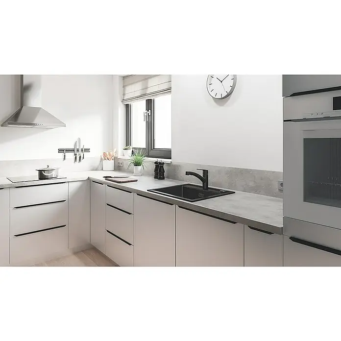 Grohe QuickFix Start Spültischarmatur - Schwarz, Schwenkbar, Matt - Moderne Küche mit weißen Schränken, Arbeitsplatte in Betonoptik und schwarzem Spülbecken. Die Dunstabzugshaube ist aus Edelstahl.
