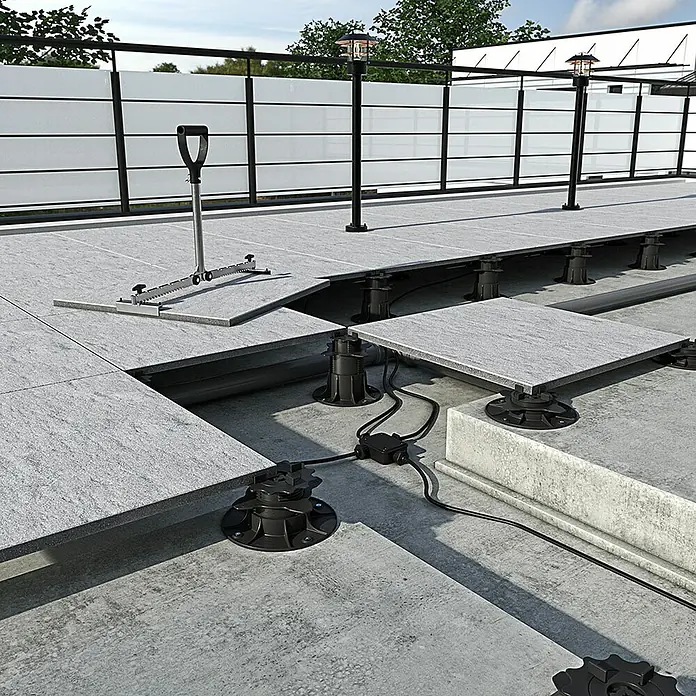 Langfit Stelzlager XL - 5 Stk., Höhenverstellung: 75 mm - 195 mm - Das Bild zeigt ein System von Stelzlagern, die eine erhöhte Terrasse aus grauen Steinplatten tragen. Die Lager sind schwarz und höhenverstellbar.