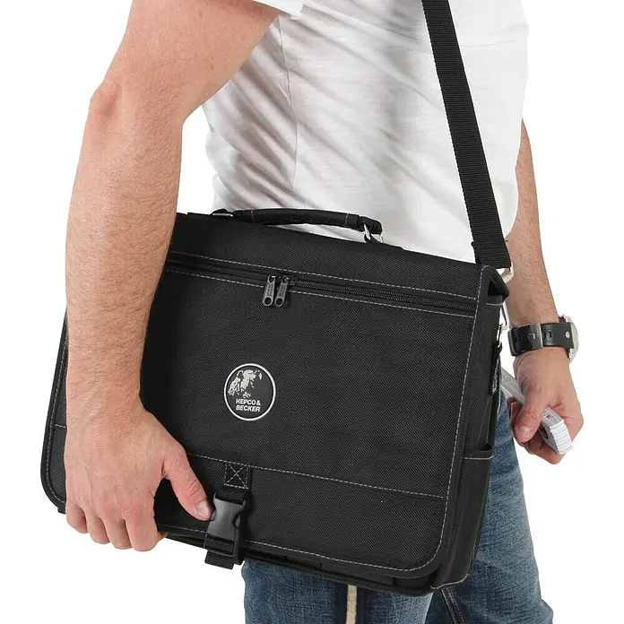 Hepco & Becker Werkzeugtasche Polytex 5851 Technikertasche - L x B x H: 100 x 390 x 300 mm, Polyester - Eine schwarze Hepco & Becker Umhängetasche wird von einer Person mit lässiger Kleidung über der Schulter getragen.