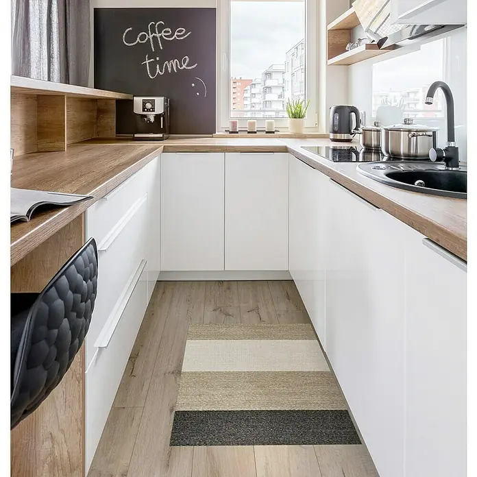Alfombra de vinilo Living Stripes - Camel, 90 x 60 cm - Imagen de cocina con un corredor de rayas en colores neutros, que acentúa el suelo de madera y crea un ambiente moderno.