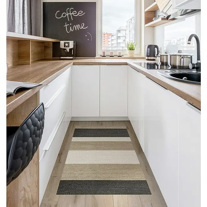 Alfombra de vinilo Living Stripes - Camel, 150 x 80 cm - Toma de cocina con un pasillo a rayas en tonos grises, beiges y marrones, que acentúa el suelo de la cocina y añade calidez al espacio.