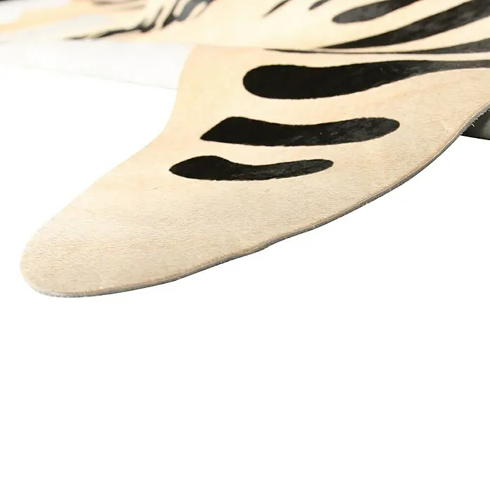 Esbeco Kuhfell - 100 % Echtfell, Zebra - Detailansicht eines eleganten Teppichs mit Zebra-Muster, der die Textur und das Design hervorhebt. Ein stilvolles Detail für moderne Wohnräume.