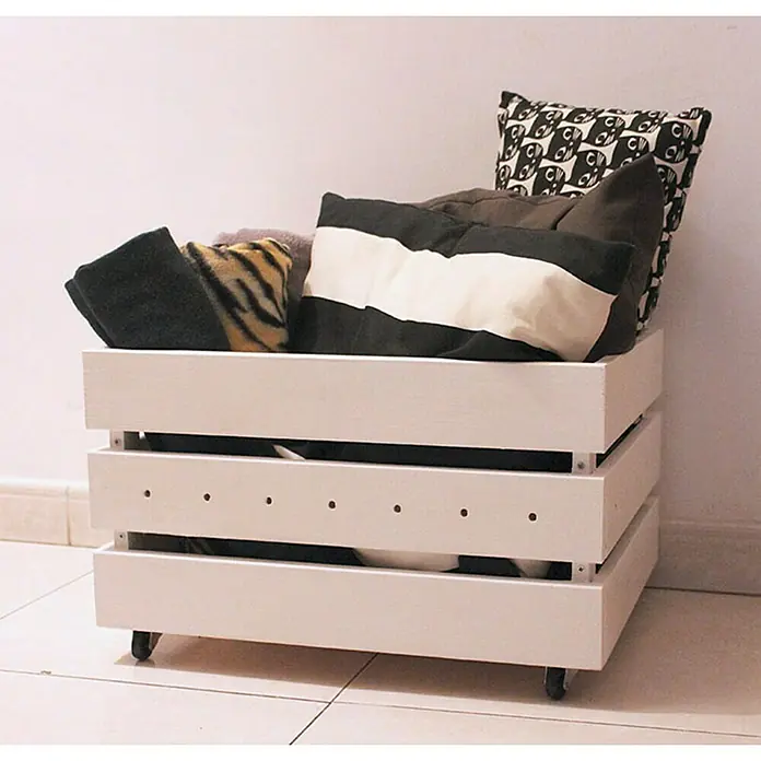 Astigarraga Home Box Holzkiste - L x B x H: 28 x 51,2 x 38,4 cm, Natur - Weiße Holzkiste auf Rollen, gefüllt mit Kissen in verschiedenen Mustern und Farben. Vielseitige Aufbewahrungslösung für stilvolles Interieur.