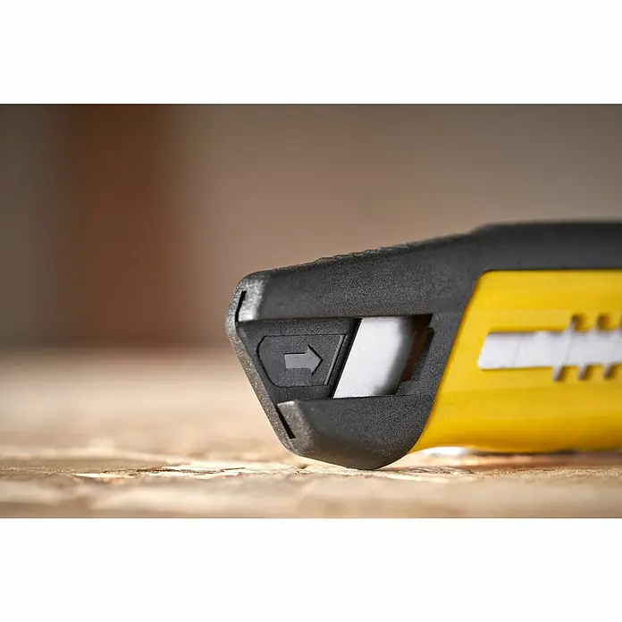 Stanley Cuchillo cúter STHT10489-0 - Plástico, Amarillo/Negro - Primer plano de un cúter amarillo y negro con hoja retráctil. El cúter está sobre una superficie de madera.