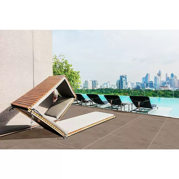 Terrassenfliese Modena - 100 x 100 x 2 cm, Taupe, Matt - Modernes verstellbares Tagesbett mit Holzlattenrahmen und grauen Polstern, geöffnet auf einer Poolterrasse mit Stadtblick.