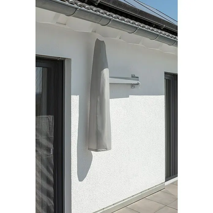 Schneider Wandschirm Muro - Anthrazit, Durchmesser Bespannung: 250 cm - Eine graue Markise ist mit einer Schutzhülle abgedeckt und an einer weißen Wand montiert. Ideal für den Schutz vor Sonne und Witterung.