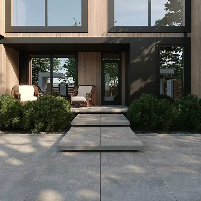 Terrassenfliese Beton - 60 x 60 x 2 cm, Hellgrau, Matt - Moderner Hauseingang mit heller Holzfassade, dunklen Rahmen, Betonstufen und üppigem Grün.