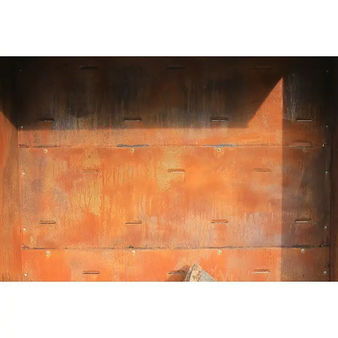 Palatino Exclusive Line Rückwand Woodpecker - 150 x 180 cm, Passend für: Palatino Exclusive Line Brennholzregal Woodpecker - Nahaufnahme eines rechteckigen, rostfarbenen Metallobjekts mit Schlitzen und Nieten, das eine industrielle und robuste Ästhetik ausstrahlt.