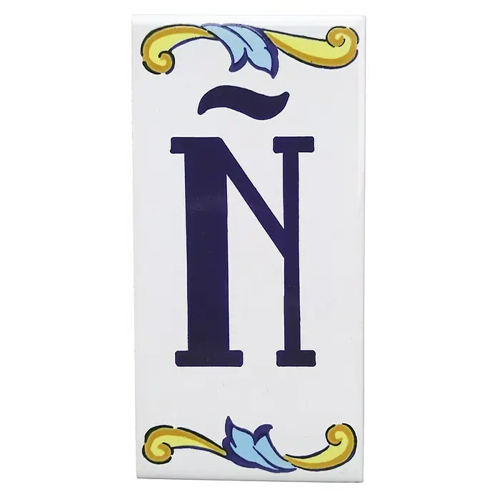 Pavimento cerámico Letra Ñ - 7,5 x 15 cm, Blanco/Azul/Amarillo, Brillante - Azulejo de cerámica con una gran Ñ azul y adornos decorativos.