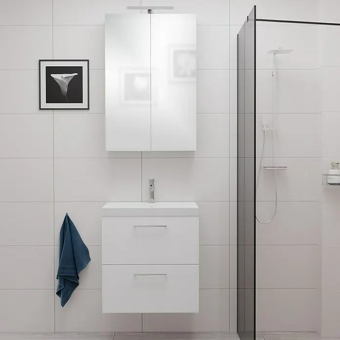 Camargue Espacio Badmöbel-Set E30 - 60 cm, Mira - Ein Badezimmer mit einem weißen Waschtischunterschrank mit zwei Schubladen und einem Spiegelschrank darüber. An der Wand hängt ein Handtuch.