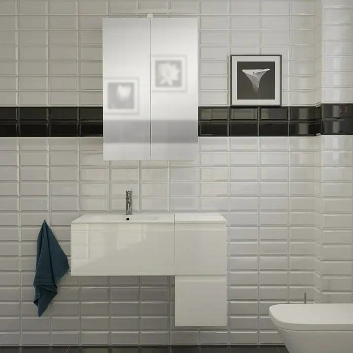 Camargue Espacio Badmöbel-Set H33 - 90 cm, Gama weiß glänzend - Ein modernes Badezimmer mit weißen Metrofliesen, einem schwarzen Fliesenband, einem weißen Waschtisch und einem Spiegelschrank.