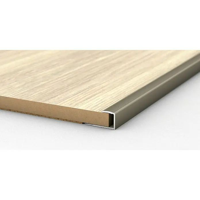 LOGOCLIC Endprofil 253 - Edelstahl matt, 0,9 m x 24 mm x 17 mm, Montageart: Kleben - Nahaufnahme einer Tischkante mit einem Aluminiumprofil, das die Kante schützt und ihr ein sauberes Aussehen verleiht.