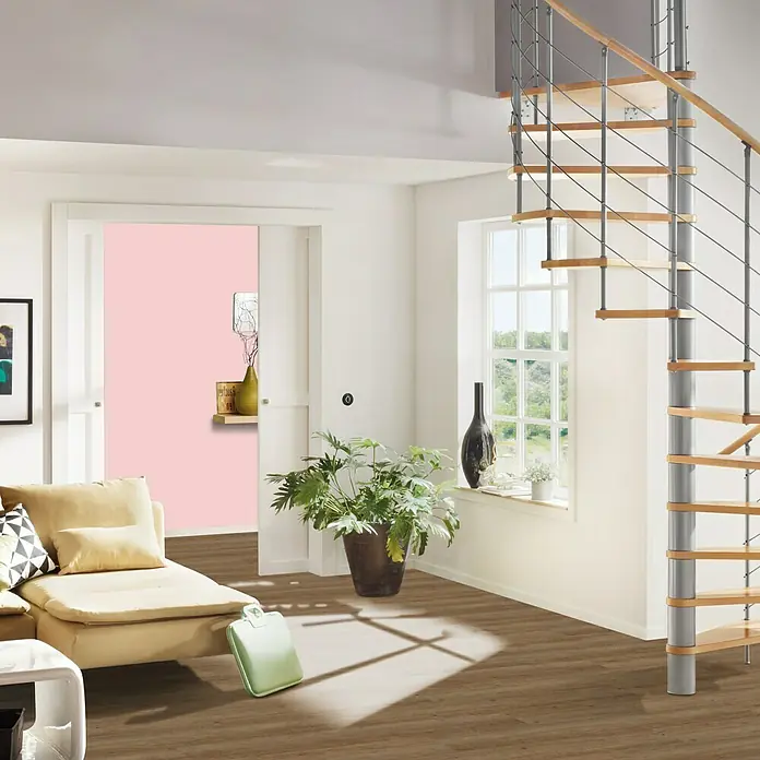 b!design Vinylbodenmuster Rigid SPC Tundra Pinie - 281 x 161 x 3,8 mm, Landhausdiele - Einladendes Wohnzimmer mit Treppe. Gemütliches Wohnzimmer mit Wendeltreppe, braunem Holzboden und einem Hauch von Grün durch die Zimmerpflanze.