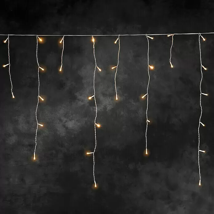 Konstsmide LED-Lichtervorhang Eisregen - Außen, 0,9 m, Bernstein, 96 Stk., Netzbetrieben - Weiße Lichterkette mit warmgelben Glühbirnen, die in leuchtenden vertikalen Strängen herabhängt.