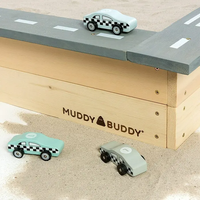 Muddy Buddy Sandkasten Highway Hero - L x B x H: 135 x 125 x 20 cm, Holz - Das Foto zeigt ein Muddy Buddy Spielzeugauto-Set mit einer Rennstrecke und drei kleinen Autos auf Sand. Perfekt für fantasievolles Spielen im Freien.