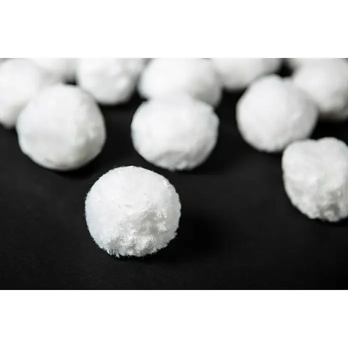 Steinbach Bola filtrante - 700 g - Primer plano de varias bolas de algodón blancas esparcidas sobre una superficie negra. Ideal para maquillaje, cuidado del bebé y primeros auxilios.