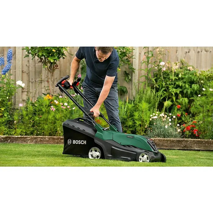 Bosch Power for All 36V Akku-Rasenmäher AdvancedlRotak 36V-40-650 - 36 V, 1 Akku, 4 Ah, Schnittbreite: 40 cm - Ein Mann bedient einen grünen Bosch Rasenmäher im Garten, umgeben von Blumen und einem Holzzaun.