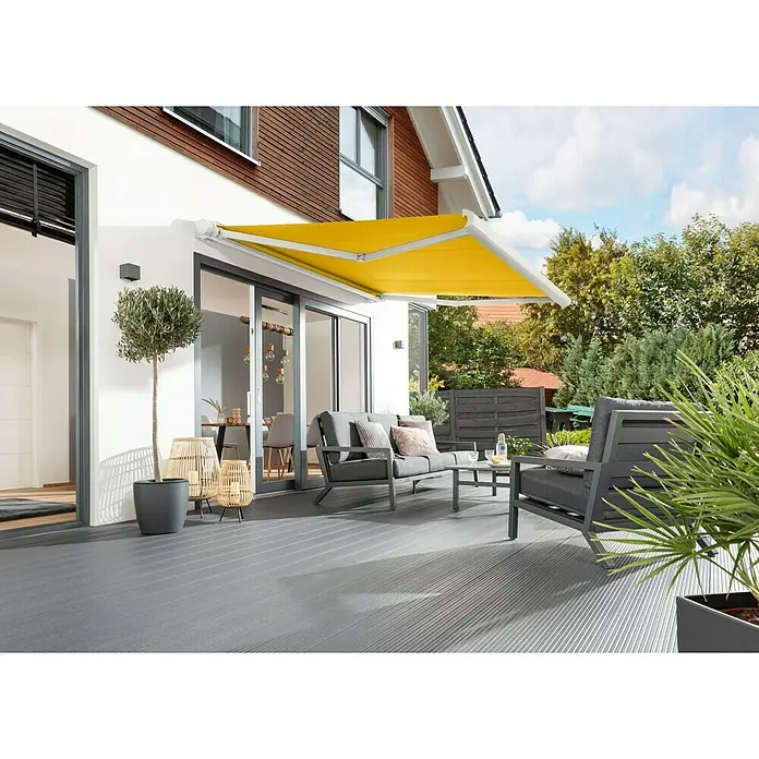 Sunfun Vollkassettenmarkise Elba - Gelb, Farbe Gestell: Verkehrsweiß, Breite: 3,5 m, Ausfall: 3 m - Gelbe Markise spendet Schatten auf einer Terrasse mit grauen Gartenmöbeln und Holzboden. Das perfekte Ambiente zum Entspannen im Freien.