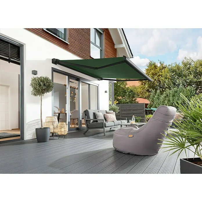 Sunfun Vollkassettenmarkise Elba - Grün, Farbe Gestell: Tiefschwarz, Breite: 4 m, Ausfall: 3,5 m - Terrasse mit stilvoller Markise, grauen Gartenmöbeln und Holzboden. Die grüne Markise spendet Schatten.