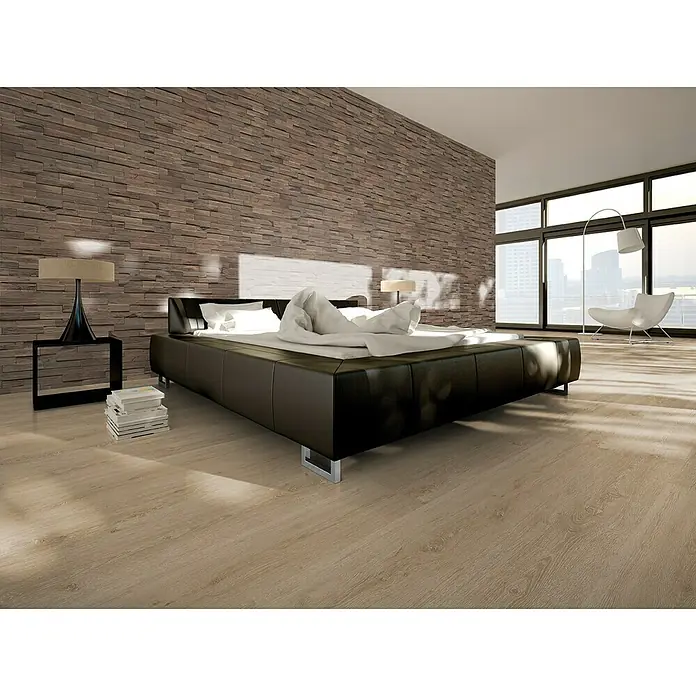 Indo Wandpaneel 3D Wall Driftwood Mindanao - Hevea, 560 x 200 x 10 mm, 1,008 m² - Ein modernes Schlafzimmer mit einem stilvollen, dunklen Lederbett und einer Akzentwand aus Ziegelsteinen.
