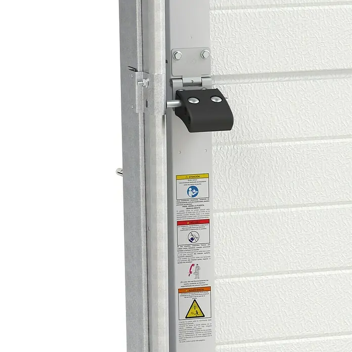 Solid Elements Puerta de garaje con motor Standard Pro - 250 x 212,5 cm, Blanco - Primer plano de una bisagra de puerta de garaje con advertencias de seguridad. La bisagra parece robusta y presenta varias pegatinas de seguridad.