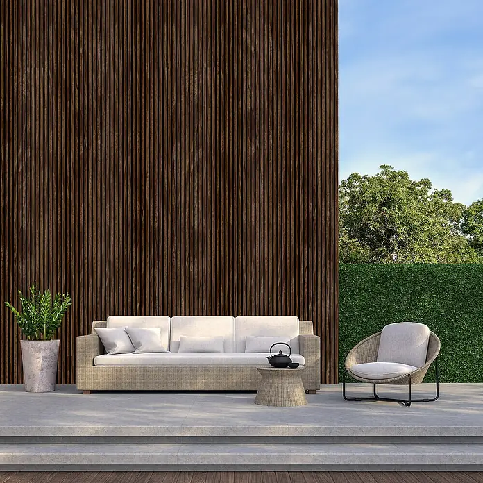 FN Neuhofer Akustikpaneel Acustico PVC - Eiche Rustikal, L x B x S: 2.400 x 572,5 x 19 mm, 1 Stk., 1,374 m² - Außenaufnahme mit Rattanmöbeln, darunter ein Sofa, ein Sessel und ein Beistelltisch, die eine entspannende Terrasse schaffen.