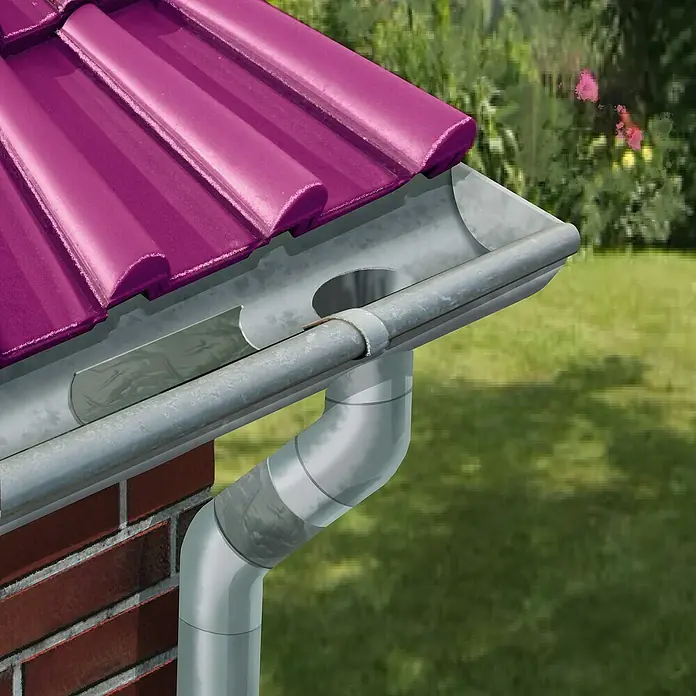 MEM Dichtband Butyl-Band - 10 m x 7,5 cm - Nahaufnahme einer Dachrinne aus Metall, die an einem Gebäude mit einem violetten Dach und einer Backsteinfassade befestigt ist.