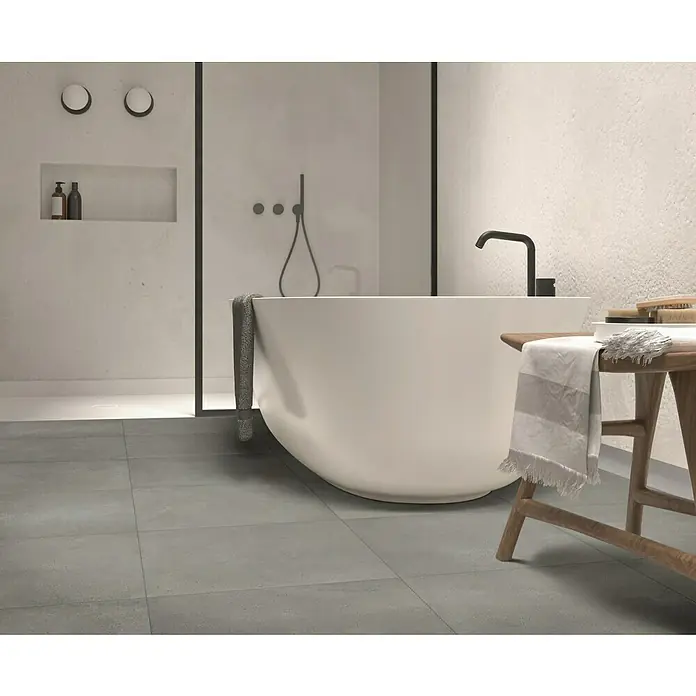 Beauflor PVC-Boden Meterware Jupiter400 cm, Tile 22, Grau - Freistehende Badewanne mit Armatur und Handtuchhalter im modernen Badezimmer mit grauen Bodenfliesen.