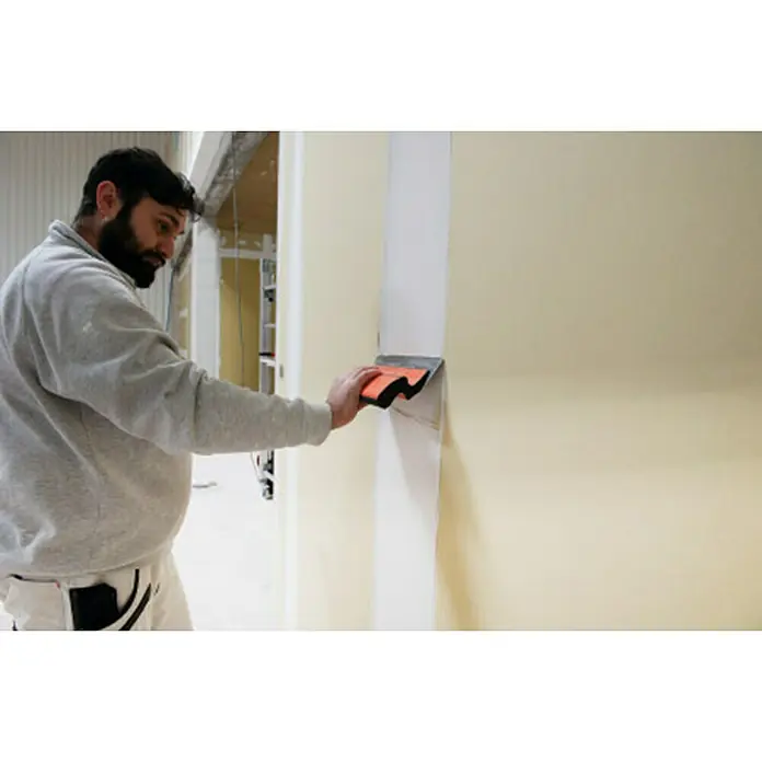 Mondelin Feinspachtel - Klingenlänge: 150 mm - Ein Handwerker glättet mit einer Spachtelmasse eine Wand, um sie für die Endbearbeitung vorzubereiten.