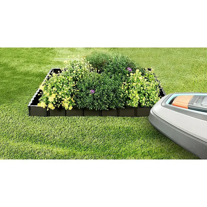 Garantia Rasenkante Edgar - Anthrazit, 75 x 0,6 x 13 cm, Polypropylen - Ein erhöhtes Gartenbeet mit Pflanzen und einem Rasenmäherroboter auf dem grünen Rasen.